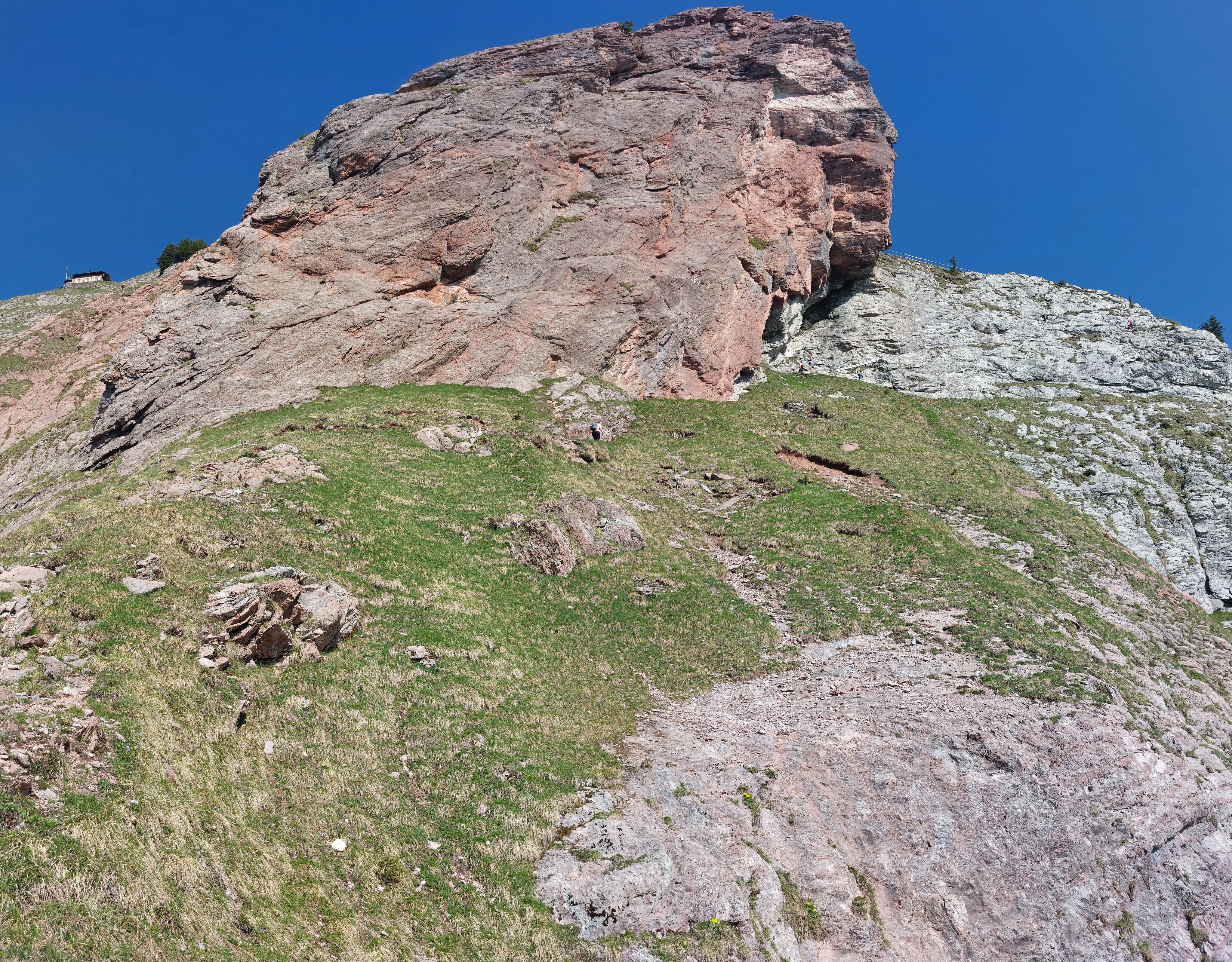Looking up at spar of red rock and summit