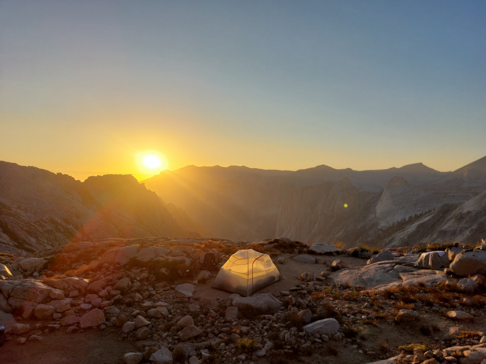 Sunset over mountains, tent in foreground